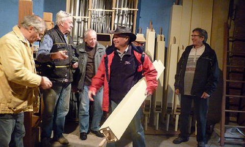 Quelques  bénévoles devant les tuyaux de bois savamment restaurés